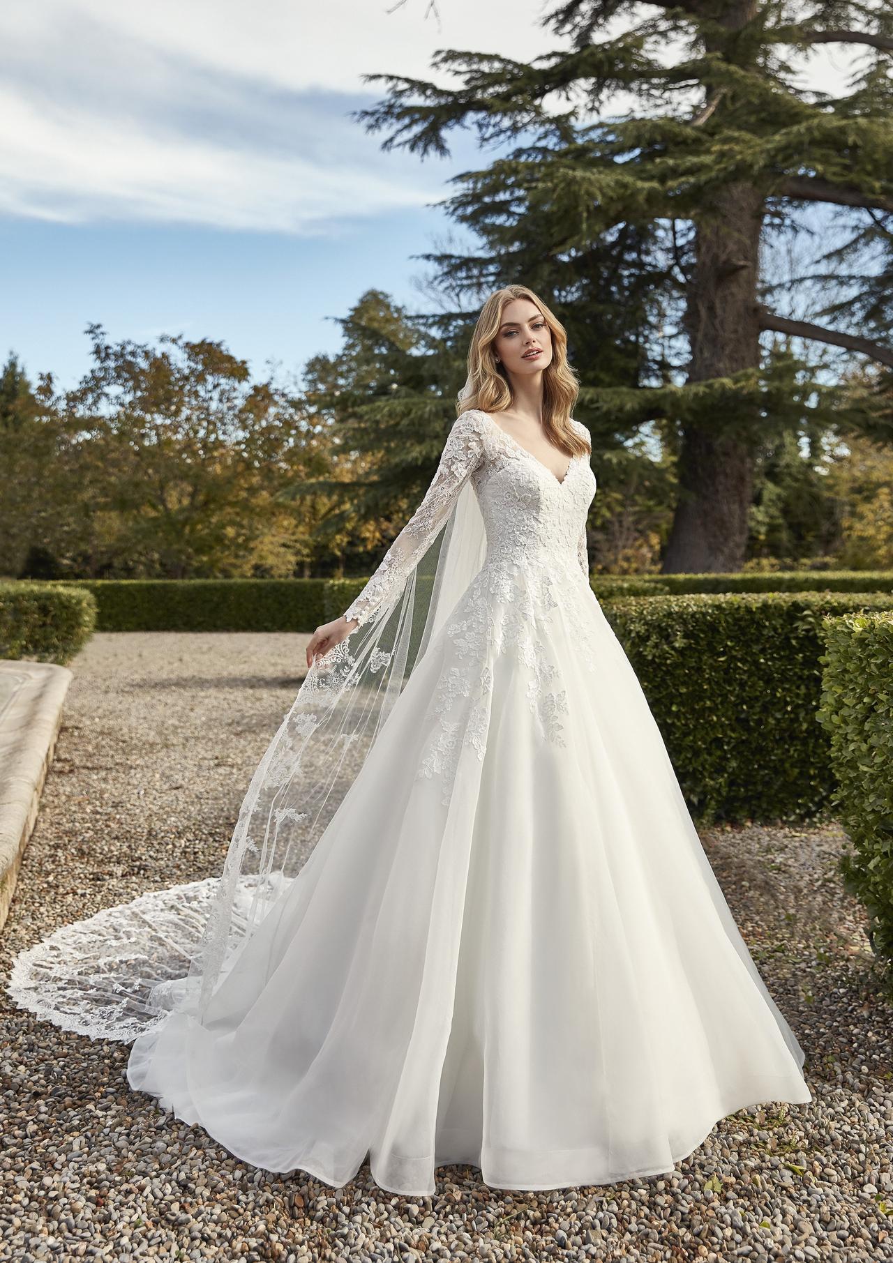 vestido de novia corte princesa con manga larga y velo como complemento