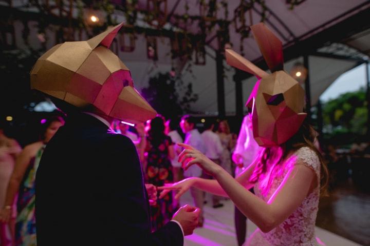 pareja de novios con máscaras en pista de baile 