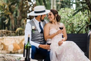 pareja de novios brindando con vino tinto en su boda