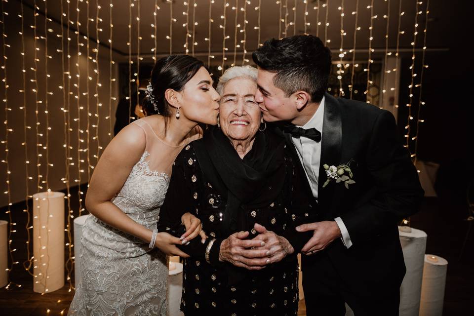 Pareja de novios dando un beso a la abuela durante la boda