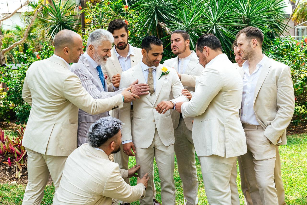 best men en bodas con traje blanco en el jardín