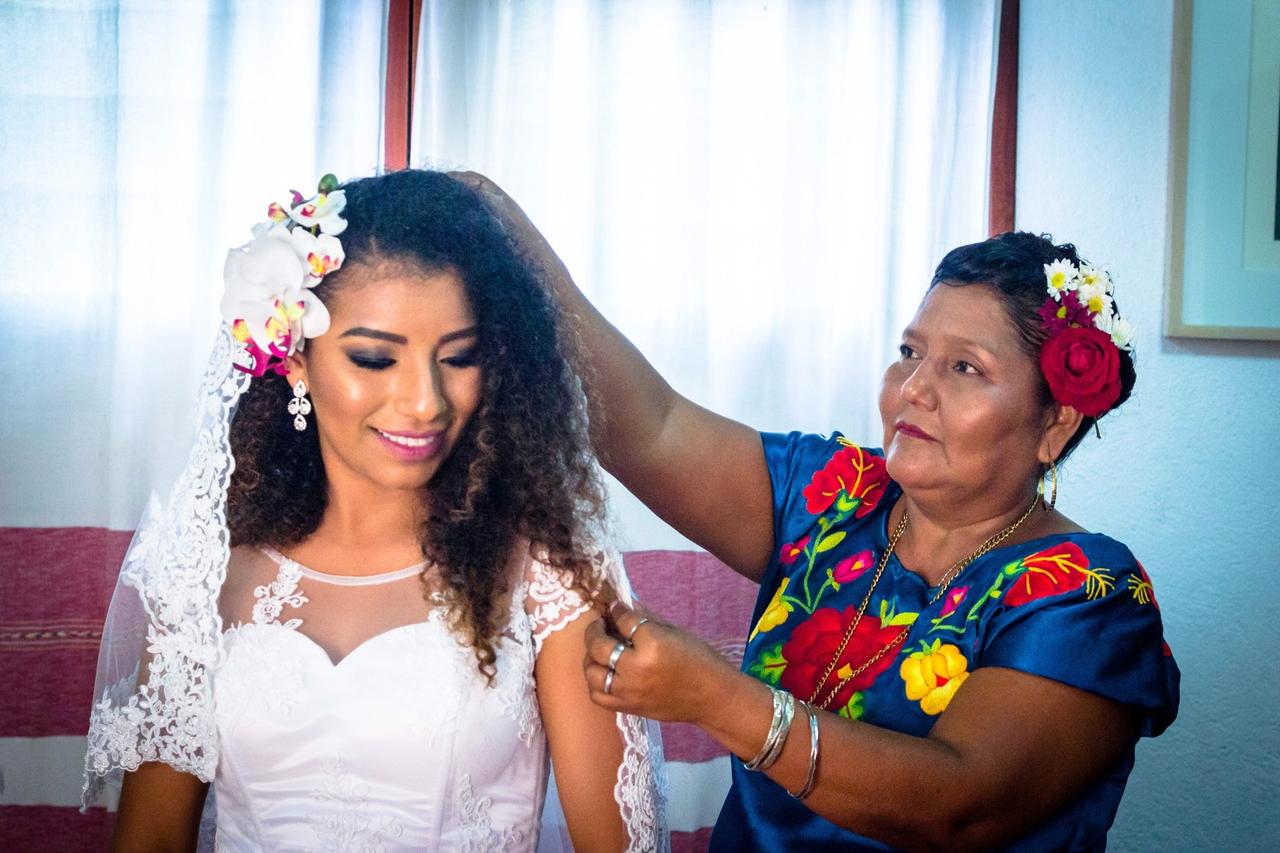 Novia con vestido y tocado en preparativos junto a su mamá