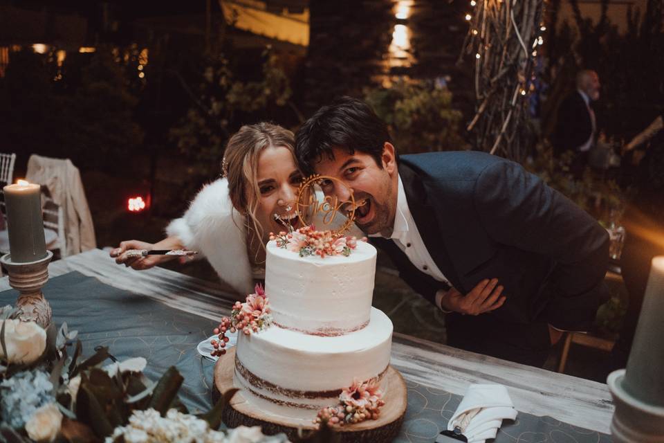 pareja de novios cortando pastel de boda