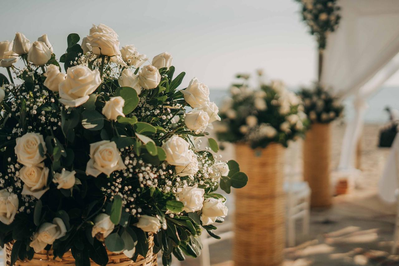 jarrones altos con hermosas flores artificiales en la mesa y el