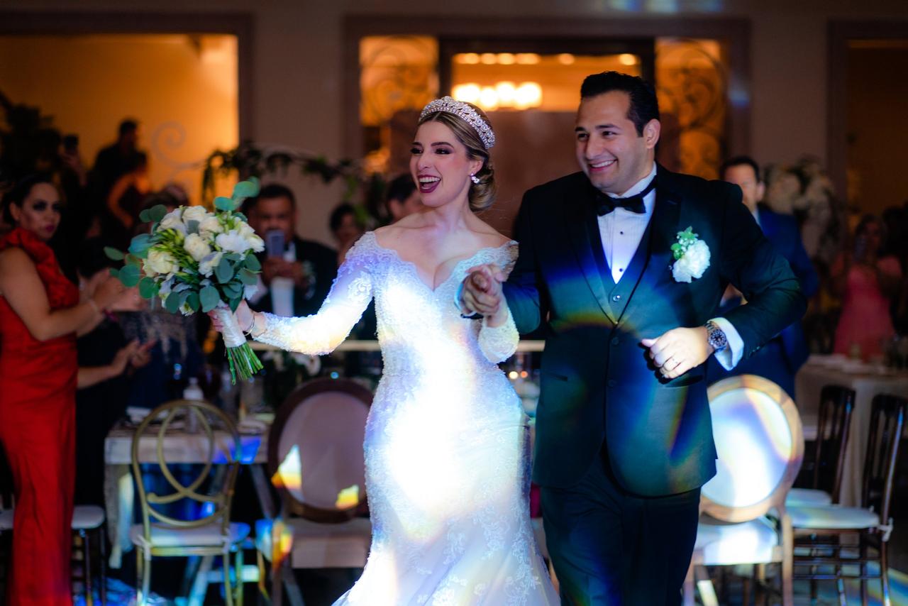 pareja de recién casados entrando al banquete de boda