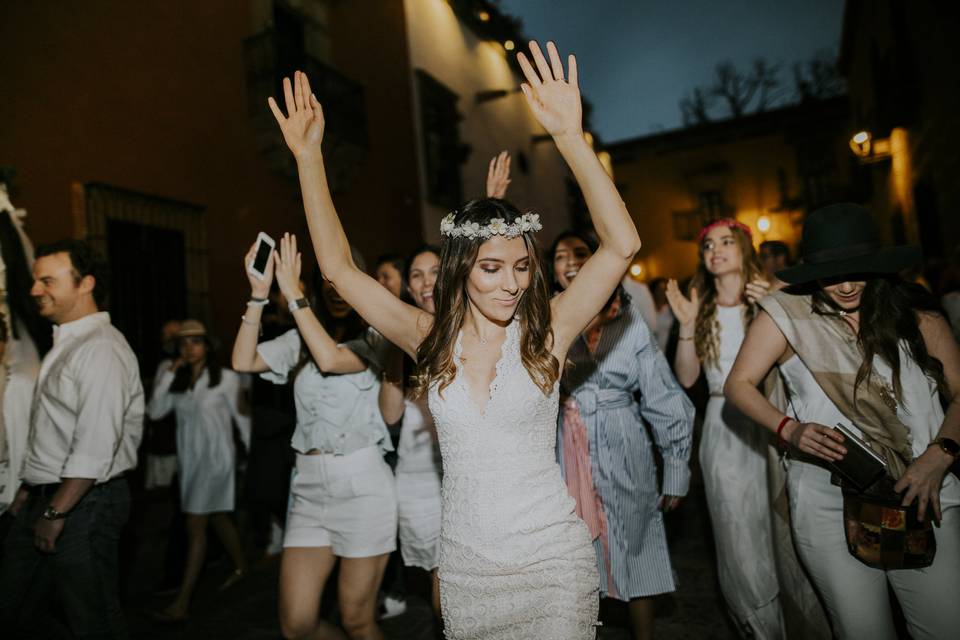 novia con vestido de encaje bailando rodeada de invitados