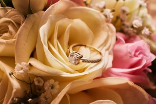 foto anillo de compromiso sobre rosa blanca del ramo de novia