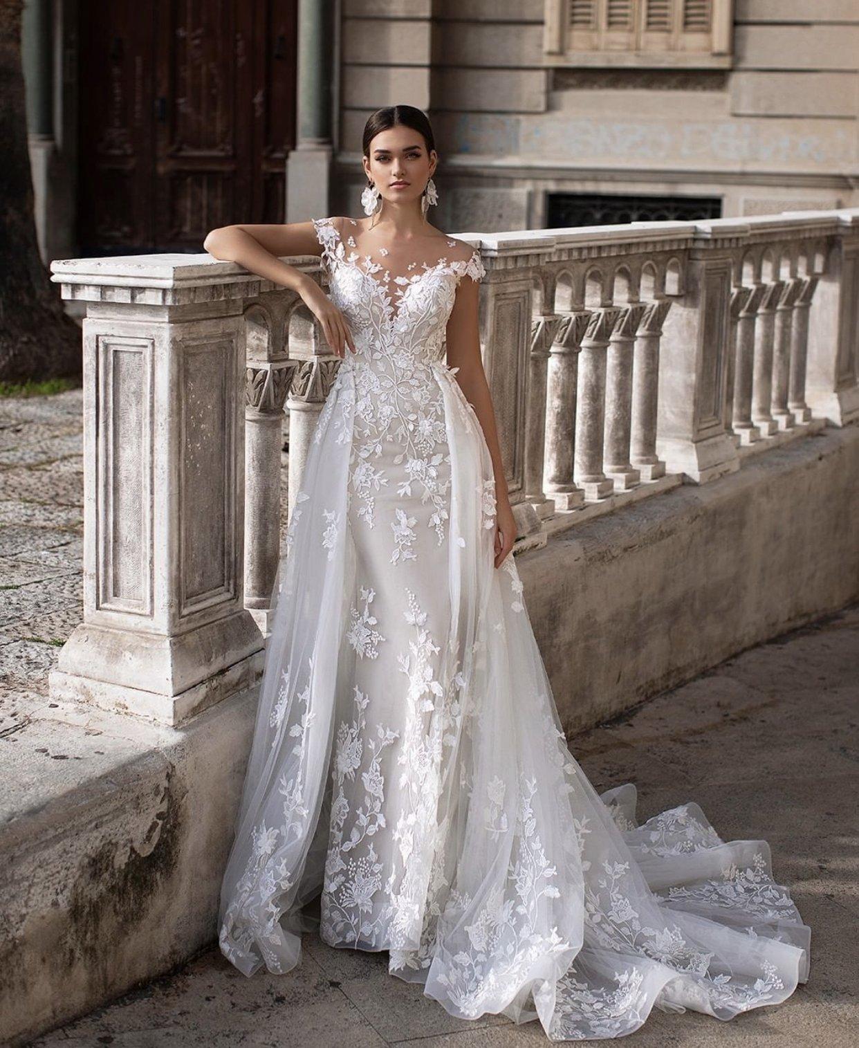 Novia glamurosa con un vestido corte sirena y sobrefalda