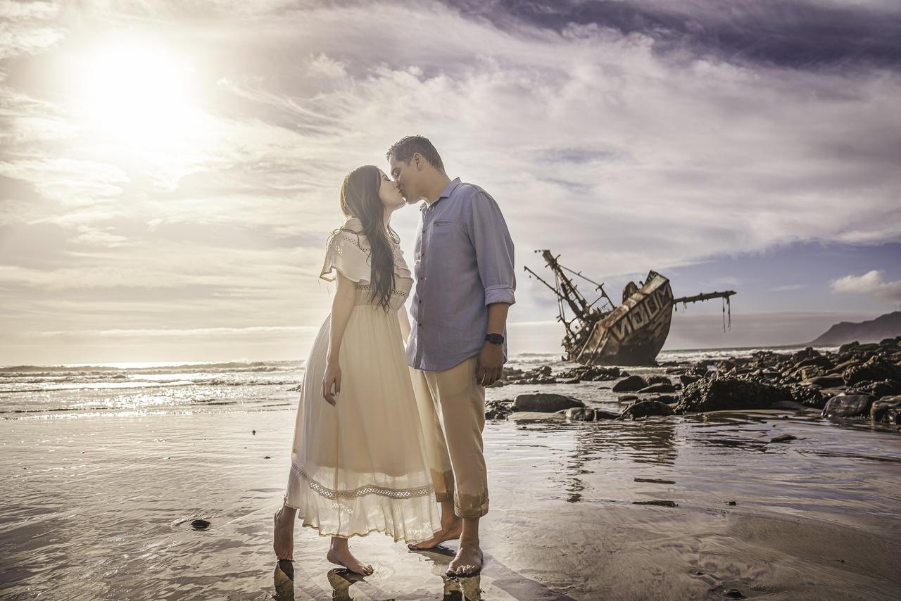 Una pareja con inteligencia emocional que hable de sus sentimientos y se de un beso frente al mar