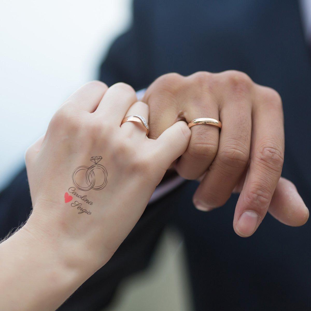 Manos de esposos con tatuajes de anillos