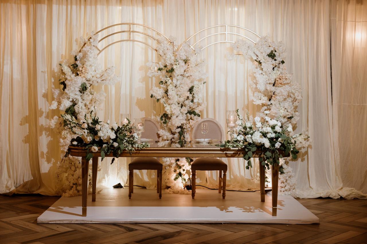 Arreglos de mesa principal para bodas elegantes en tonos blancos con arcos