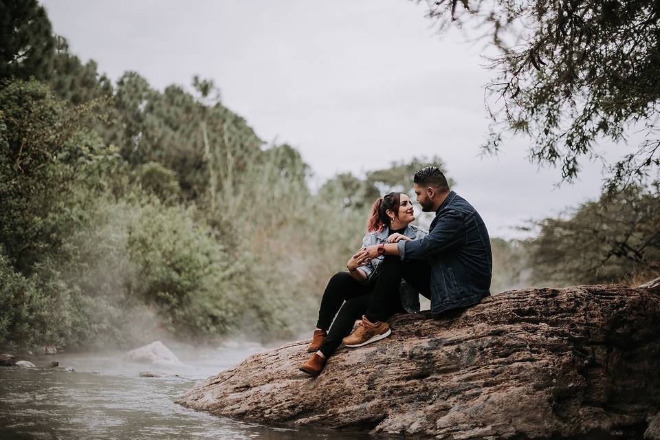 pareja de enamorados sentados frente a un río