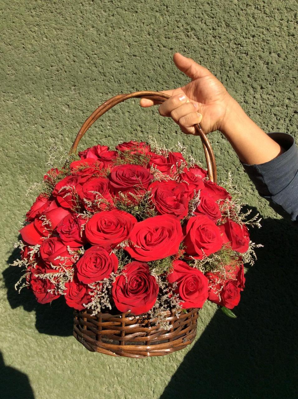 Arreglos florales en canastas con rosas rojas