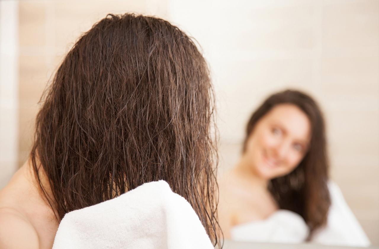 mujer secándose el cabello con toalla