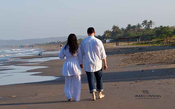 Caminar en la orilla del mar, tomados de la mano