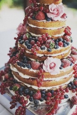 Pastel Naked Cake de vainilla decorado con frutos rojos y la rebanada ira bañada de mermelada de fru