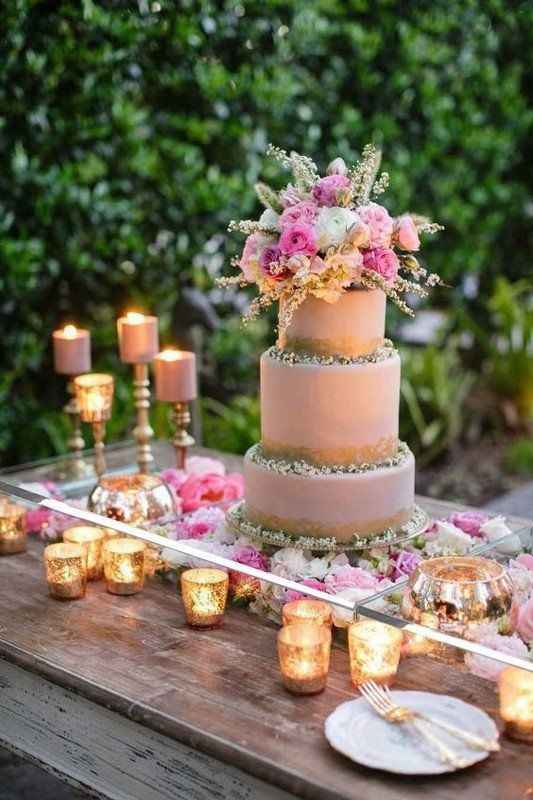 Mesa de vidrio con flores y velas