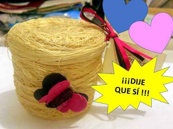 una cajita de yute con mariposas vivas y en el fondo el anillo