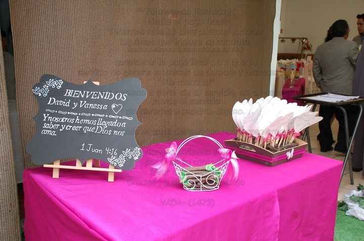 Mesa de bienvenida con los abanicos para mujeres y burbujeros para niños.