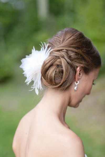 Recogido enroscado lateral con detalle de flor blanca.