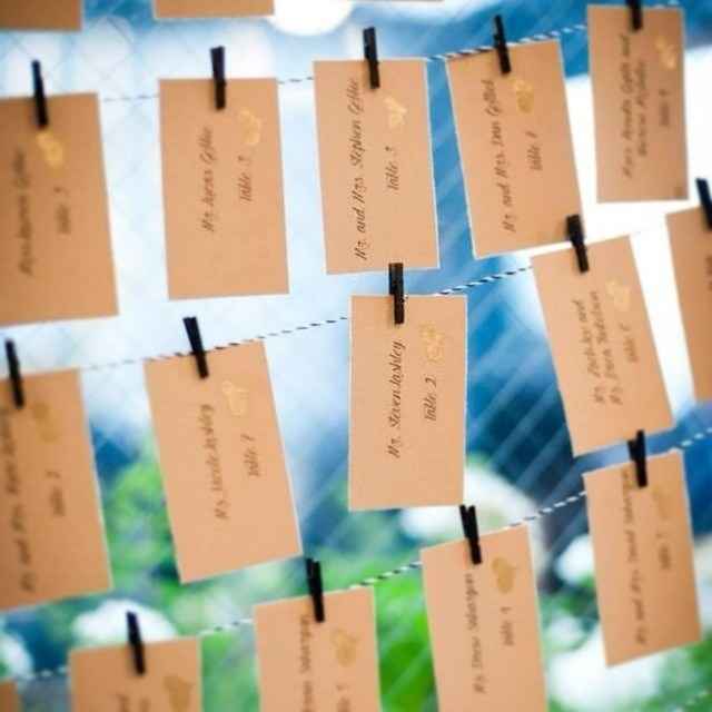 Seating para una boda con papeles con pinzas en cuerdas