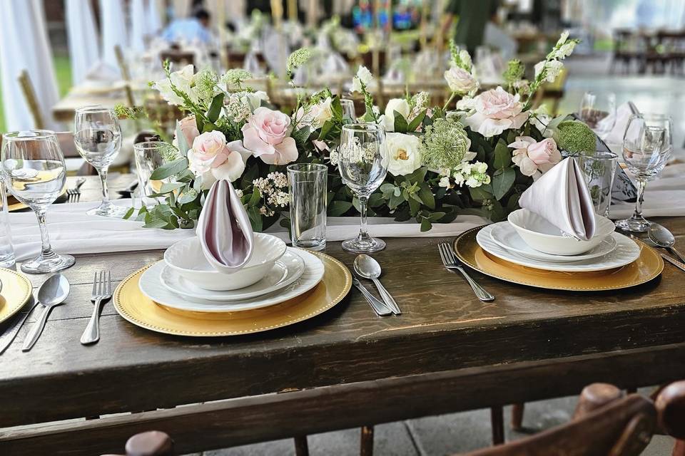 Mesa con vajilla blanca y arreglo floral de rosas