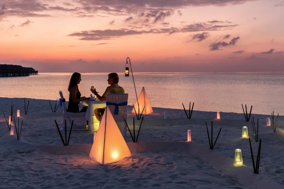 Pareja en una cena en la playa en el atardecer