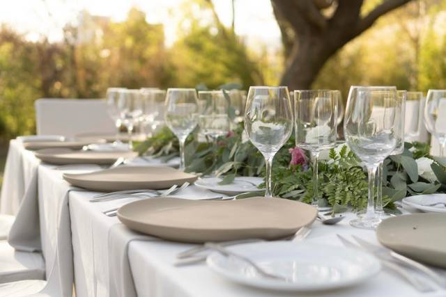 Mesa con copas de cristal y platos beige