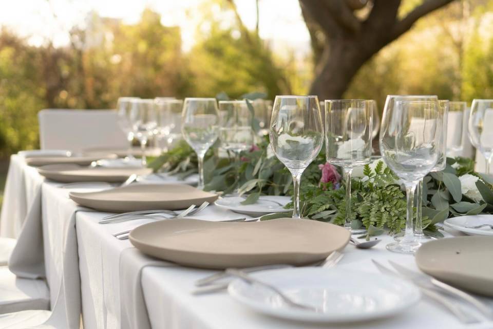 Mesa con copas de cristal y platos beige