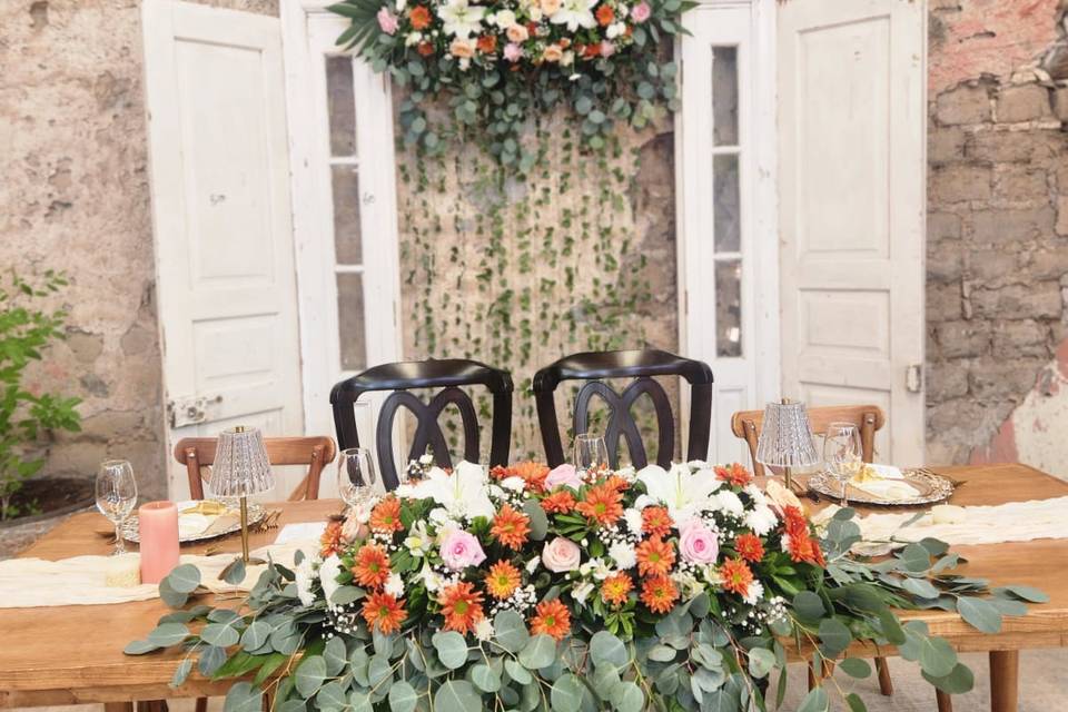 Mesa de madera decorada con rosas y flores naranjas