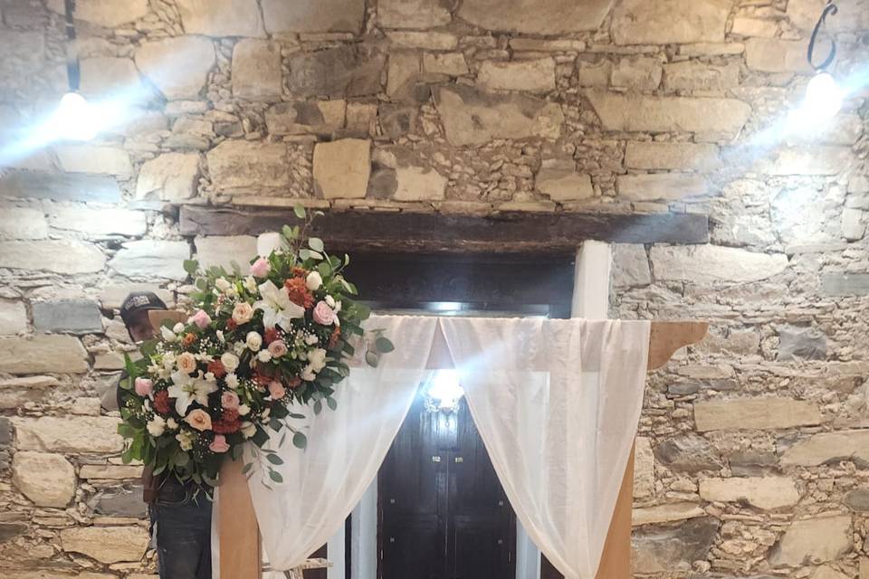 Mesa de novios decorada con flores y un back de tela blanca con flores