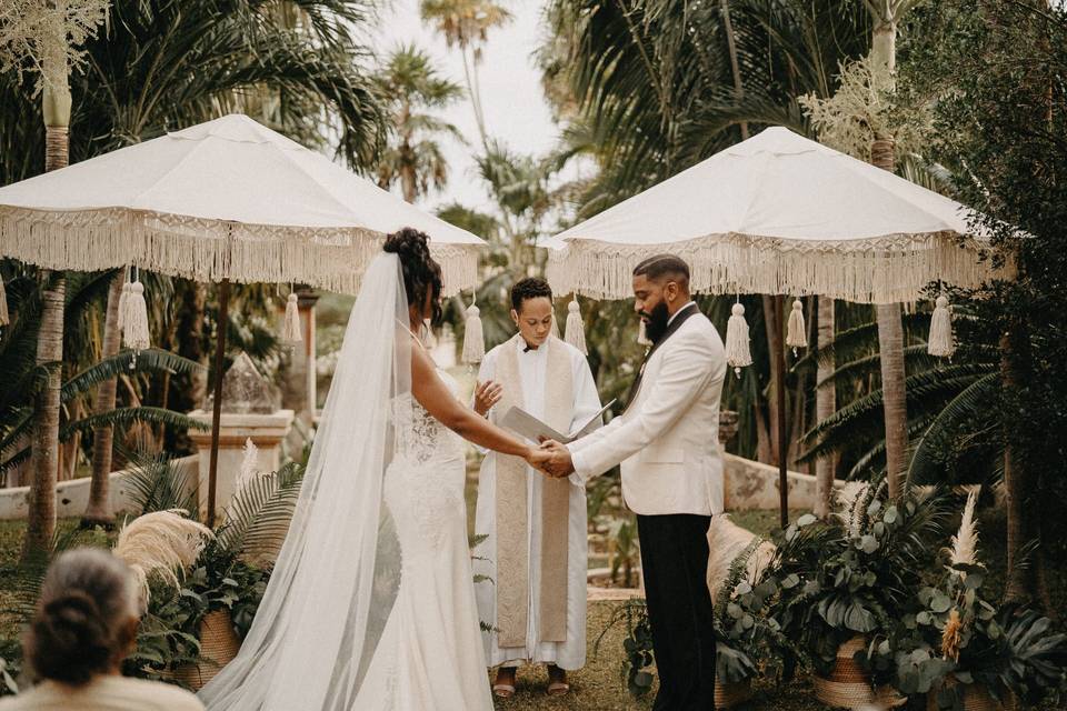Novios agarrados de la mano frente al padre