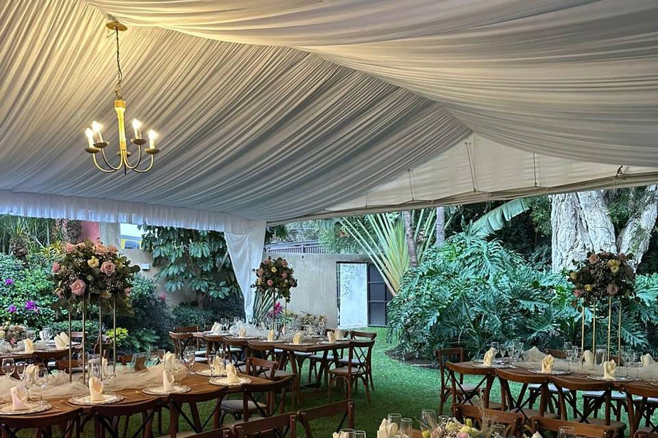 Montaje de mesas en jardín y carpa blanca