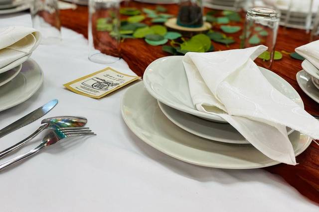 Mesa con vajilla blanca y florero en el centro