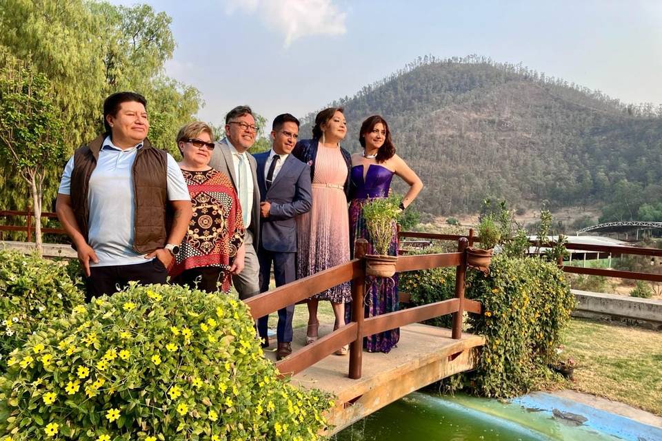 Familia posando en un puente y las montañas de fondo