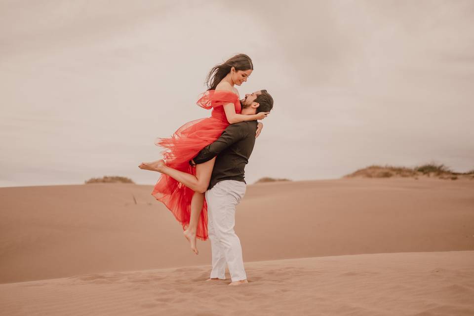 Novio cargando a la novia en el desierto