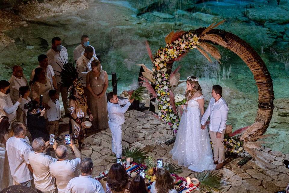 Novios agarrados de la mano en ceremonia en cenote