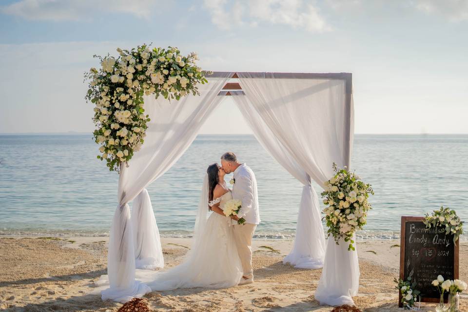 Novios besándose en el altar frente a la playa