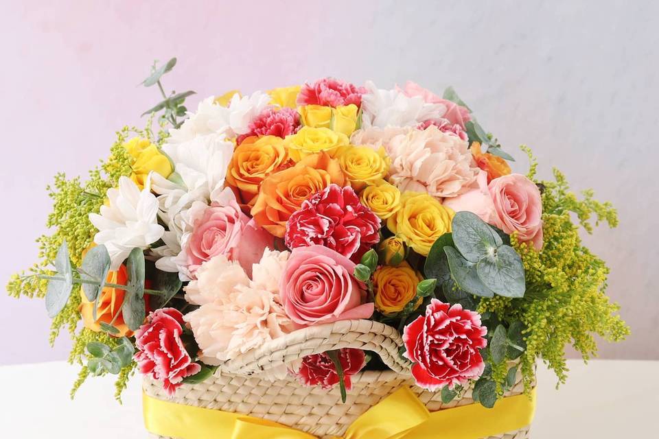 Canasta de flores rosas y amarillas
