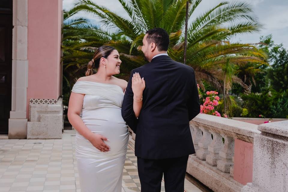 Pareja con los brazos entrelazados posando en un patio