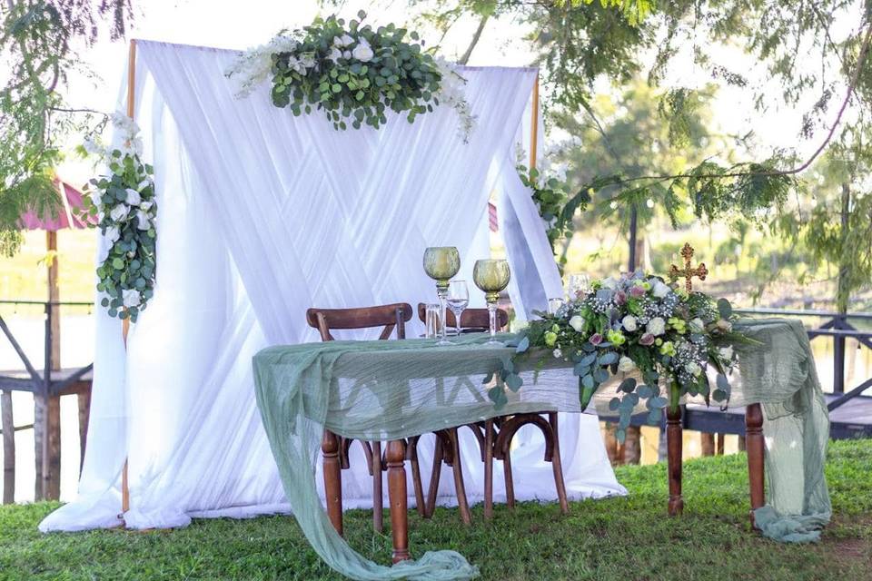 Mesa de novios con telas blancas y verdes