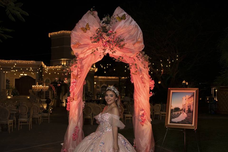Novia posando en un arco iluminado