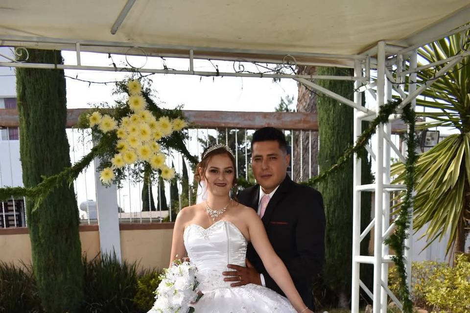 Novio agarrando de la cintura a la novia en un jardín