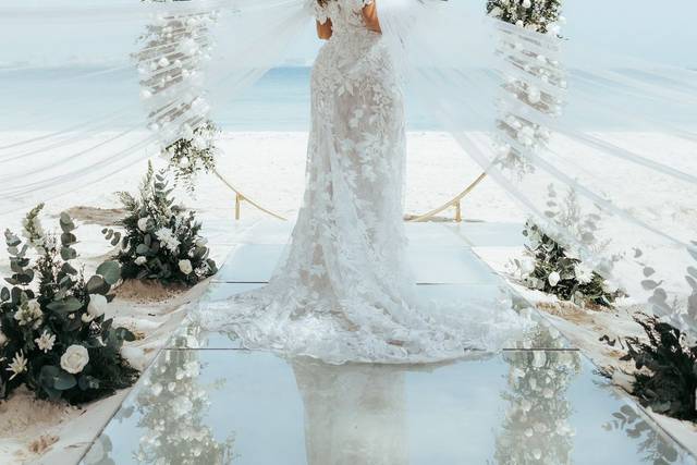 Novia de espaldas frente a un arco de flores