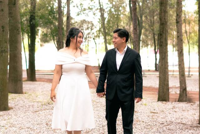 Pareja caminando de la mano en medio del bosque