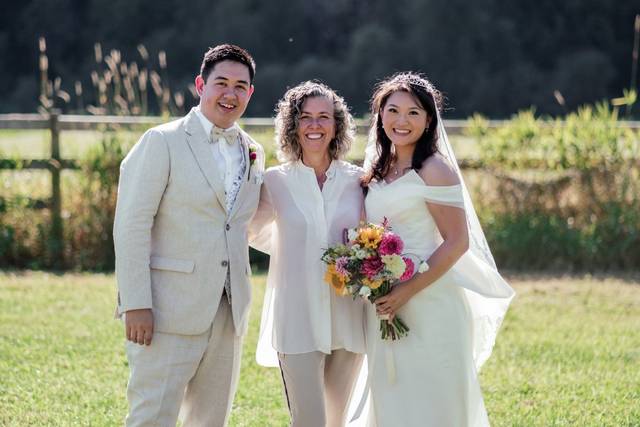 Novios posando con la oficiante de boda