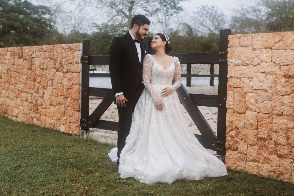 Pareja en el jardín frente a un muro de piedra