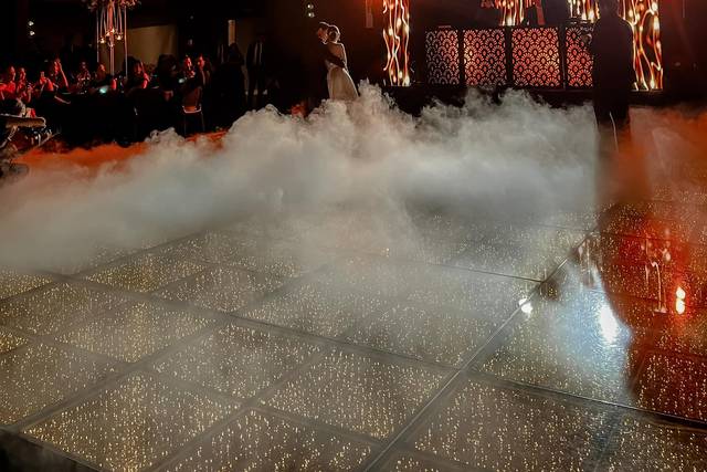 Novios bailando en la pista con humo