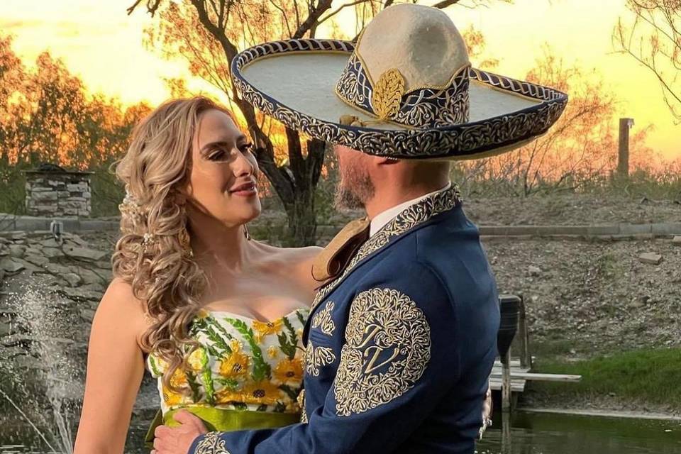 Novio vestido de charro y novia con vestido bordado con flores amarillas