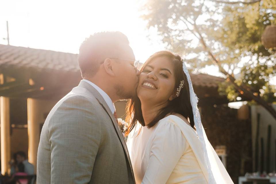 Novio dándole un beso en el cachete a la novia